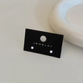 Close-up of minimalist white bean stud earrings presented on a black jewelry display card - White Gold Plated