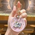 Portachiavi tondo in pelle rosa con distintivo in metallo corgi e dettagli floreali in mano - Rosa