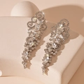 Détail macro de boucles d'oreilles à pompons argentés avec strass sur socle en pierre - Boucles d'Oreilles Pendantes Feuilles Motif Strass Argent (HE24229)