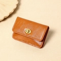 Detail of vintage brown leather wallet featuring a gold swivel lock and fine stitching - Orange