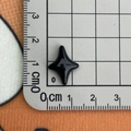 Macro d'une petite étoile noire en résine montrant la taille de 1,5 cm sur une règle - Noir