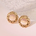 Close-up of vintage gold-rimmed button earrings with pink stone and lattice texture - White