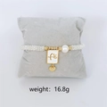 Elegant white beaded elastic bracelet featuring gold heart charm and square fé pendant - White Fé Faith Charm Bracelet (Silver Color)