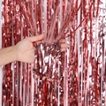Detail van een glanzend rood metallic franjegordijn met textuur en handgehouden effect - Roségoud