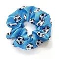 Detailed view of bright blue satin scrunchie featuring classic black and white soccer prints - Blue