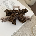 Leopard print bow hair claw clip displayed on a book with coffee cup background - Transparent Base Bow Style (Claw Clip-Transparent-Coffee-Bow) / Coffee Leopard
