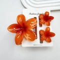Three-piece vibrant orange resin plumeria flower hair claw clip set on a display card - Dark Orange Set (including Cards)