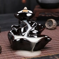 Glossy black ceramic backflow incense burner with mountain cascade design on bamboo mat - Steadily Rising