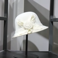 Detail of white wool cloche hat featuring a large 3D knitted flower on metal stand - M (56-58cm) / White