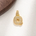 Close-up of gold-plated letter Q pendant with micro-pave crystals on white paper - Letter Q