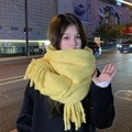 Soft yellow cashmere-feel winter scarf with thick tassels shown in a night city street - Lemon Yellow