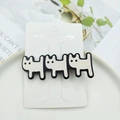 Detail of three cream cat-shaped acetate hair clips on a white display card in a ceramic dish - Beige