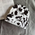 Close-up of knit texture on cow print beanie with stylish white and brown patterns - One Size / Coffee Cow Print