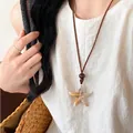 Close-up of ocean-style starfish pendant on brown cord with a rustic wood bead detail - 26# Necklace-Coffee