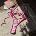 Two-piece floral bikini set with pink trim and adjustable ties on white plush carpet - Rose Red