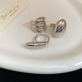 Detailansicht von drei polierten silbernen organischen Ringen auf einer Keramikplatte - Stil 4 (3er-Set) / Silber