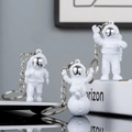 Three white astronaut keychains set with silver visors in standing and sitting poses - No.2 Silver 3-Piece Keychain Set