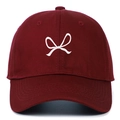 Close-up of a burgundy cotton baseball cap with white bow embroidery and curved brim - Burgundy