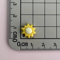 Vista dall'alto di un piccolo sole in resina giallo e bianco con misura 1,5 cm su tappetino - Sole Giallo