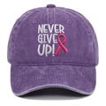 Detail der Stickerei 'NEVER GIVE UP!' und rosa Schleife auf lila gewaschener Baumwollkappe - Baseballcap / Lila
