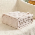 Soft light beige waffle weave plush blanket folded neatly on a cozy lamb wool sofa - Off White