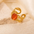 Detail of gold open ring featuring oval orange gemstone and hollow braided texture - Braided Orange Cat's Eye Adjustable Style (TYR0719)