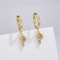 Close-up of golden letter P earring with clear zircons on a white geometric cube - Letter P (Style: 0229)