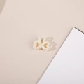 Close-up of elegant bow-shaped pearl mini hair claw clip with cream white beads - Bow Tie