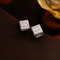 Nahaufnahme geometrischer quadratischer Ohrringe mit Zirkonia auf braunem Stoff - Silberfarbene Quadratische Ohrstecker Mit Buchstaben M (S925-Stift)