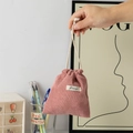 Detail view of pink corduroy drawstring storage bag with soft texture and white fabric label - Dusty Pink