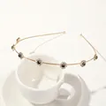 Detailed shot of golden leaf headband with black stones and crystals on white cup - Metal Headband-Plum Gold Black Zirconia
