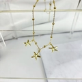 Detail van gouden kralenketting met drie getextureerde zeesterbedeltjes op een standaard - Zeester