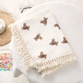 Detail of soft cream cotton baby blanket featuring brown bear prints and fringe edges - Single Bear