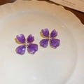 Detail view of vintage purple flower earrings with gold edges and pearl center on a white plate - 31# Silver Pin-Gold-Purple
