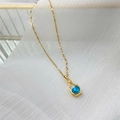 Collier bouteille à voeux dorée avec pendentif coeur en zircon bleu sur tissu blanc - Verseau