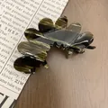 Eleganter Haarspange aus Acetat mit Schildpatt-Marmor-Muster auf einem rustikalen Holztisch - Dunkelbraun