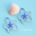 Vista macro di ciondoli a stella marina in resina bianco satinato e blu, misura 2,3x2,5cm - Stella Bianca Smerigliata