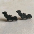 Close-up of black wooden bat stud earrings for Halloween, featuring natural wood texture - Bat