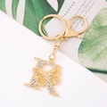 Detail of a gold butterfly-shaped letter R keychain with sparkling crystal rhinestones - Letter R