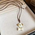 Close-up of white puppy and bone pendant on a brown cord in a beige jewelry box - Cream Puppy Head Bone Resin Pendant Necklace / 54# Necklace-Cream-Puppy