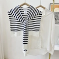 Gestreepte gebreide sjaal in marineblauw en wit gedrapeerd over een wit shirt met lange mouwen - Wit met marineblauwe strepen