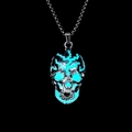 Detailaufnahme eines silbernen Totenkopf-Anhängers mit blau leuchtenden Rissen und Kette - Türkisfarbenes Leuchten