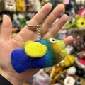 Detailed close-up of a handmade colorful wool felt fish keychain with metallic ring - Purple