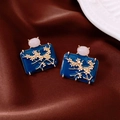 Nahaufnahme von Vintage-Emaillohrring mit Blumenmuster und rosa Stein auf Satin - Silbernadel-Blau