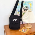 Graziosa borsa a tracolla in tela nera con fiocco bianco su tavolo in legno - Nero