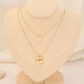 Dettaglio di una collana a doppio strato dorata con ciondolo a cuore e zircone su un busto - Stile Cuore 3D con Gemma Singola (11#)