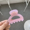 Pink translucent butterfly hair claw clip with golden spring held in hand - Jelly Pink