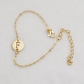 Golden bracelet with a hollow circular pendant featuring the engraved letter F - Gold F