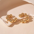 Dettaglio di ear cuff dorati geometrici a C con trama a perle metalliche lucide - Ear cuff - Oro