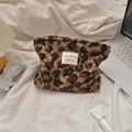 Gros plan d'une trousse à maquillage en peluche léopard avec étiquette de marque - Léopard Marron